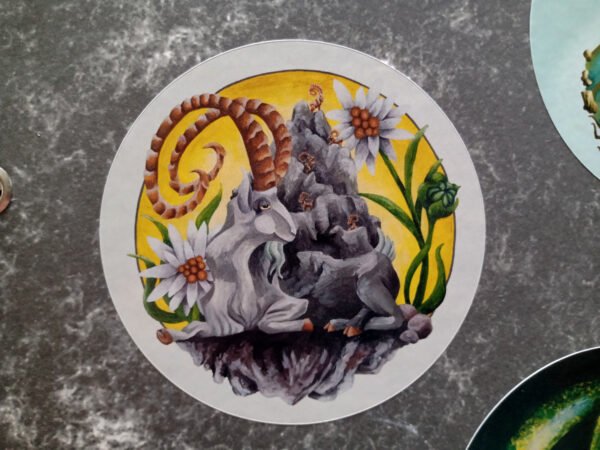 Colourful Round Sticker of the fantasy acrylic painting “Mountain Goat Elder” by Imogen Smid stuck on grey work folder