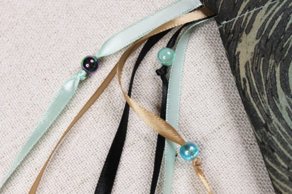 Close Up of mint spray Glastonbury Tor Pouch with mint, taupe and black ribbons and iridescent mint and black plastic beads