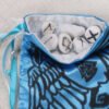 Blue poly-satin huginn, muninn, valknut pouch with white taffeta lining, rune stones spelling Imogen are sitting in the pouch