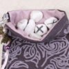 Purple Cotton knotwork tree pouch with light purple taffeta lining, white rune stones that spell Imogen sitting in the pouch