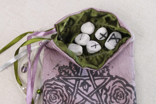 Purple taffeta pentagram pouch with moss green poly-satin lining, white rune stones that spell Imogen are in the pouch