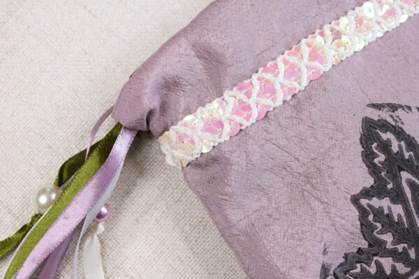 Close Up of pale purple rose pentagram Pouch with iridescent white and pink sequins band woven with a diamond shaped pattern